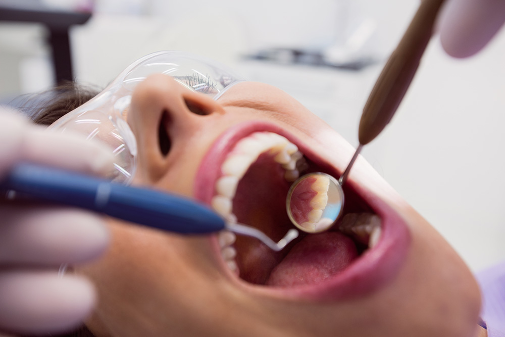 dentista-examinando-una-paciente-con-herramientas